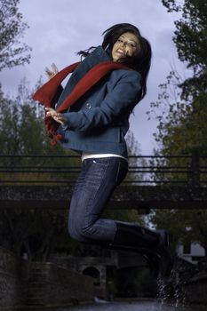 Young beautiful woman wearing winter clothing playful on a urban park.