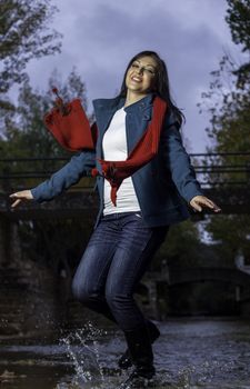 Young beautiful woman wearing winter clothing playful on a urban park.