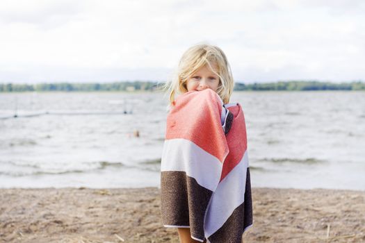 A 7 year old child wrapped up in a towel after a swim