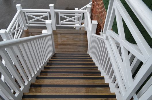 Ornate wooden stairway which connects a buildings first level to ground floor.