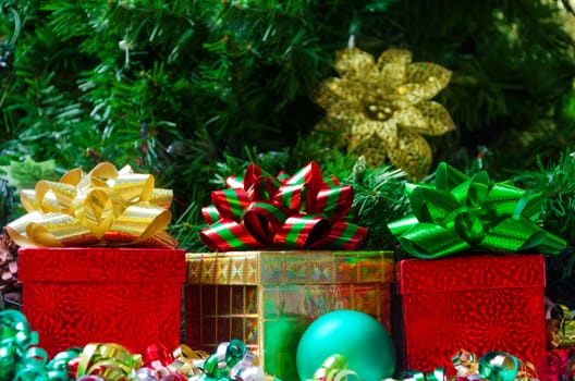 Three gift boxes with ball on the Christmas tree background