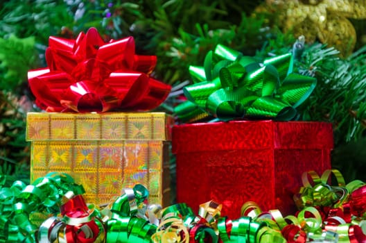 Two gift boxes with bows on the Christmas tree background