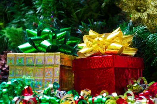 Two gift boxes with bows on the Christmas tree background