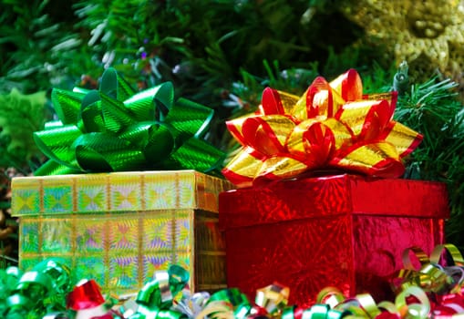 Two gift boxes with bows on the Christmas tree background