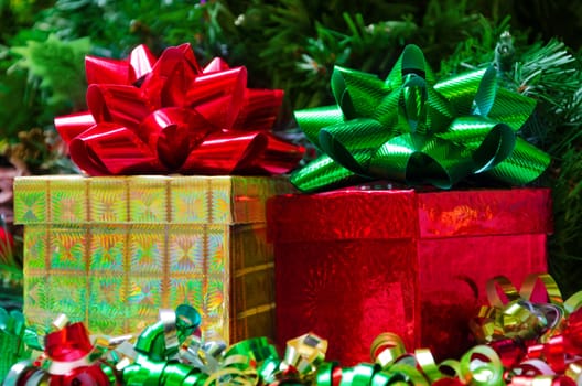 Two gift boxes with bows on the Christmas tree background