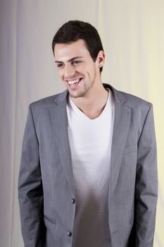 View of a young man standing against a white  background. 