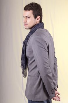 View of a young man standing against a white  background. 