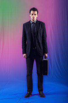 View of a young business man standing against a colorful  background. 