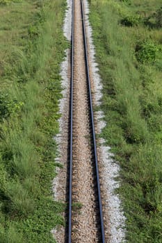 rail road way with green grass beside