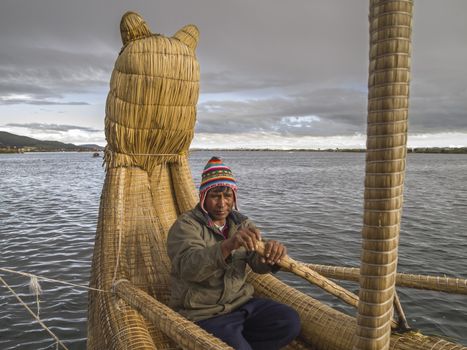 PUNO, PERU - MAR 13: Peruvian rows Totora Reed boat on Mar 13, 2011 in Lake Titicaca, Puno, Peru. These reeds have been used by various pre-Columbian South American civilizations to build reed boats.
