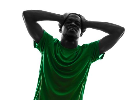 one african man soccer player green jersey despair loosing in silhouette  on white background