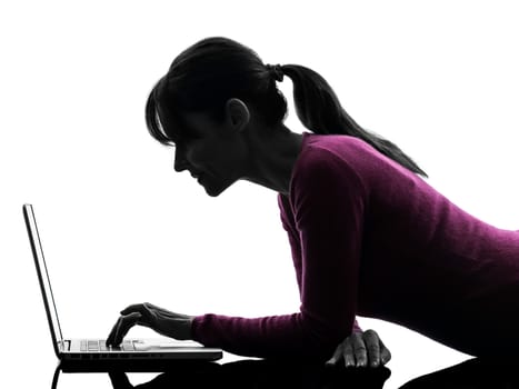 one caucasian woman serious computing laptop computer  in silhouette studio isolated on white background