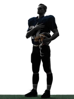 one caucasian american football player man hand on heart in silhouette studio isolated on white background