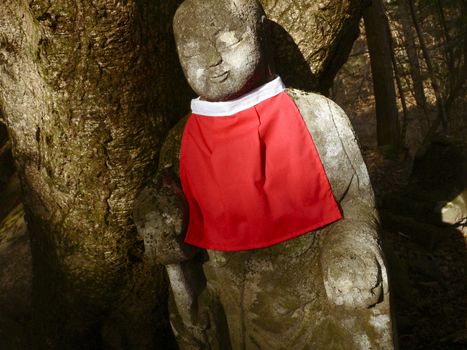ancient stone sculpture of Japanese Jizo in mountain forest area
