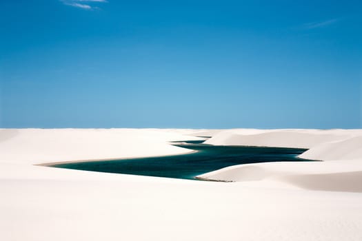 view of lagoa azul in desert white sand dunes of the Lencois Maranheses National Park in brazil