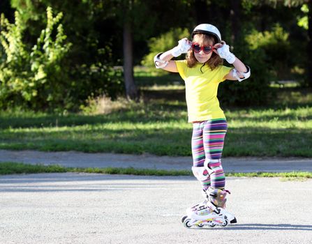 little girl with roller skates and sunglasses