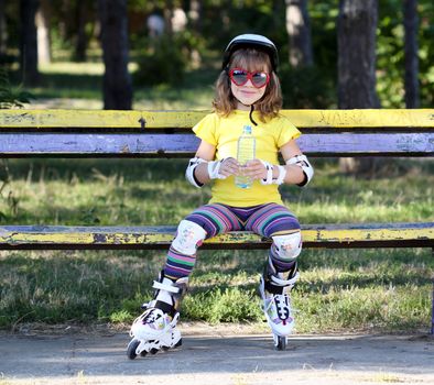 little girl with roller skates and water