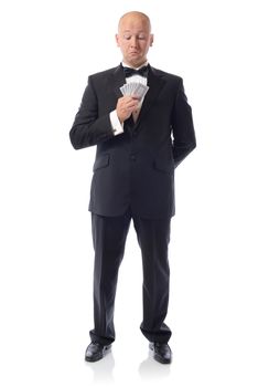 Man in tuxedo looking at hand of playing cards isolated on white