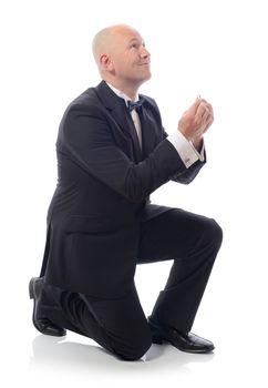 man in tuxedo down on bended knee proposing isolated on white