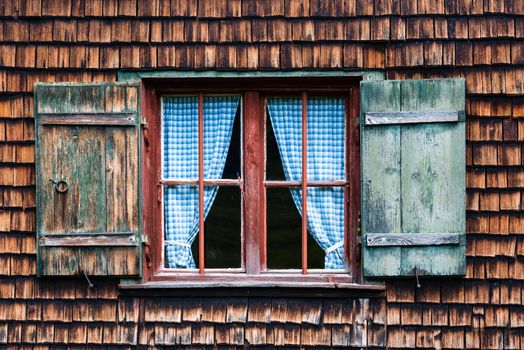 Idyllic Bavarian alpine cottage - window with curtains and wooden panels