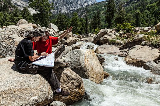 Hiker trekkers read a trekking map on trek in Himalayas mountains. Himachal Pradesh,India