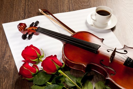 Red roses and a violin on the table