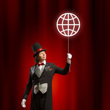 Image of man magician with balloon against color background
