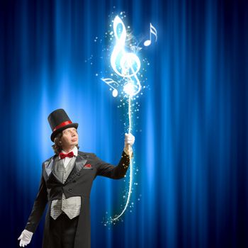 Image of man magician showing trick against color background