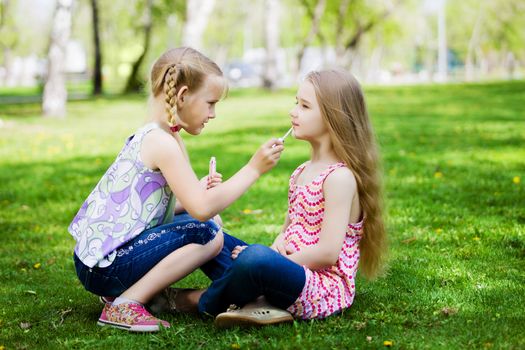 Image of two little cute girl playing on grass in park