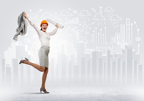 Young woman engineer in helmet jumping joyfully