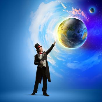 Image of magician in hat holding globe. Ecology concept. Elements of this image are furnished by NASA