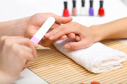 Young woman is getting manicure in a beauty salon