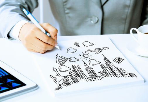 Image of businesswoman sitting at table and drawing sketch