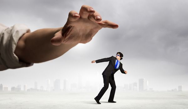 funny image of businessman trying to run away from hand