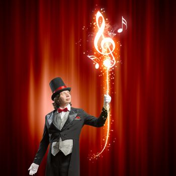 Image of man magician showing trick against color background