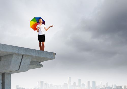 Image of businesswoman standing at the edge of bridge. Risk concept