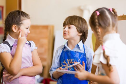 Little children painting and playing at kindergarten