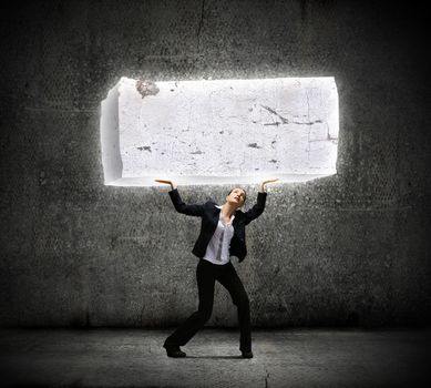 Image of young businesswoman holding burden above head