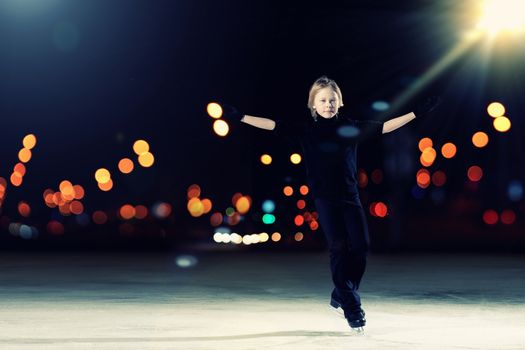 Young boy figure skating at sports arena