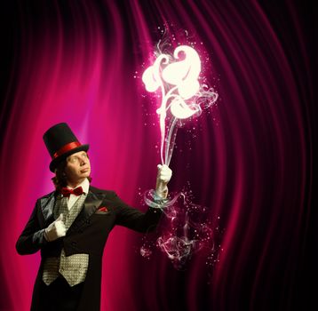 Image of man magician showing trick against color background