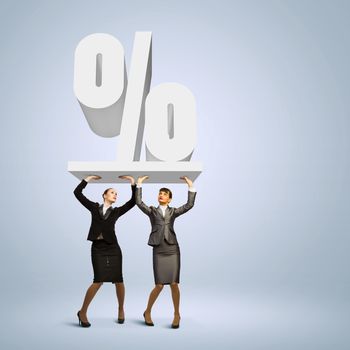 Image of two businesswomen holding percentage symbol above head