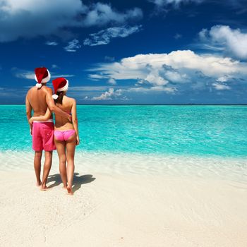 Couple in santa's hat on a tropical beach at Maldives