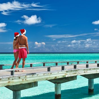 Couple on a tropical beach jetty at Maldives