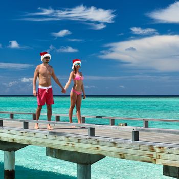 Couple on a tropical beach jetty at Maldives