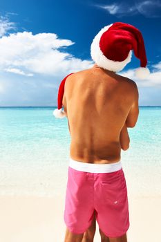 Couple in santa's hat on a tropical beach at Maldives