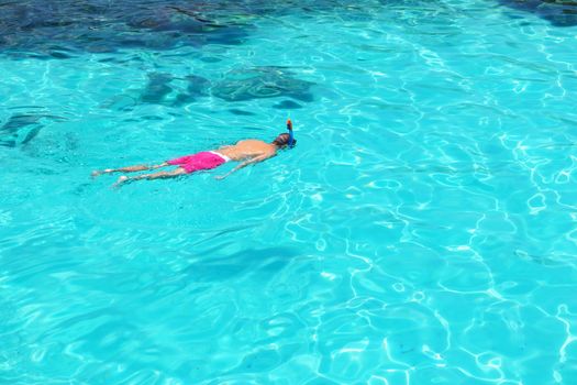 Man snorkeling in crystal clear turquoise water at tropical beach