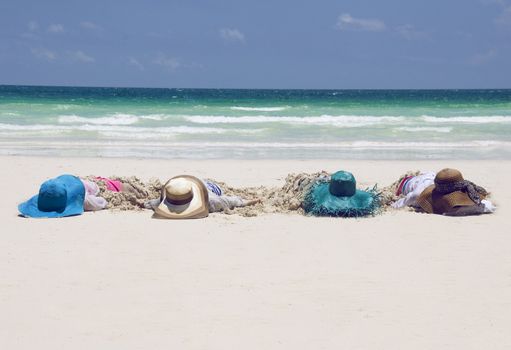 Girls with hats on a tropical beach