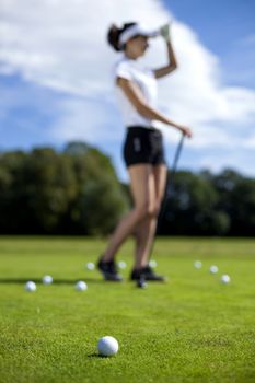 Pretty girl playing golf on grass in summer