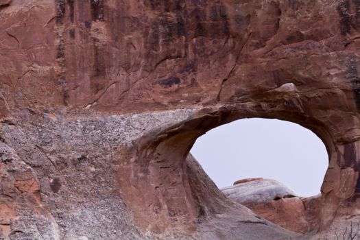 Arches National Park, iconic Southwestern desert area in Moab, Utah, famed for its distinctive sandstone arches; location within park is at Devil's Garden; view through stone arch;