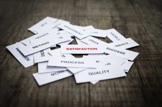 Paper strips with Satisfaction related words on wooden background